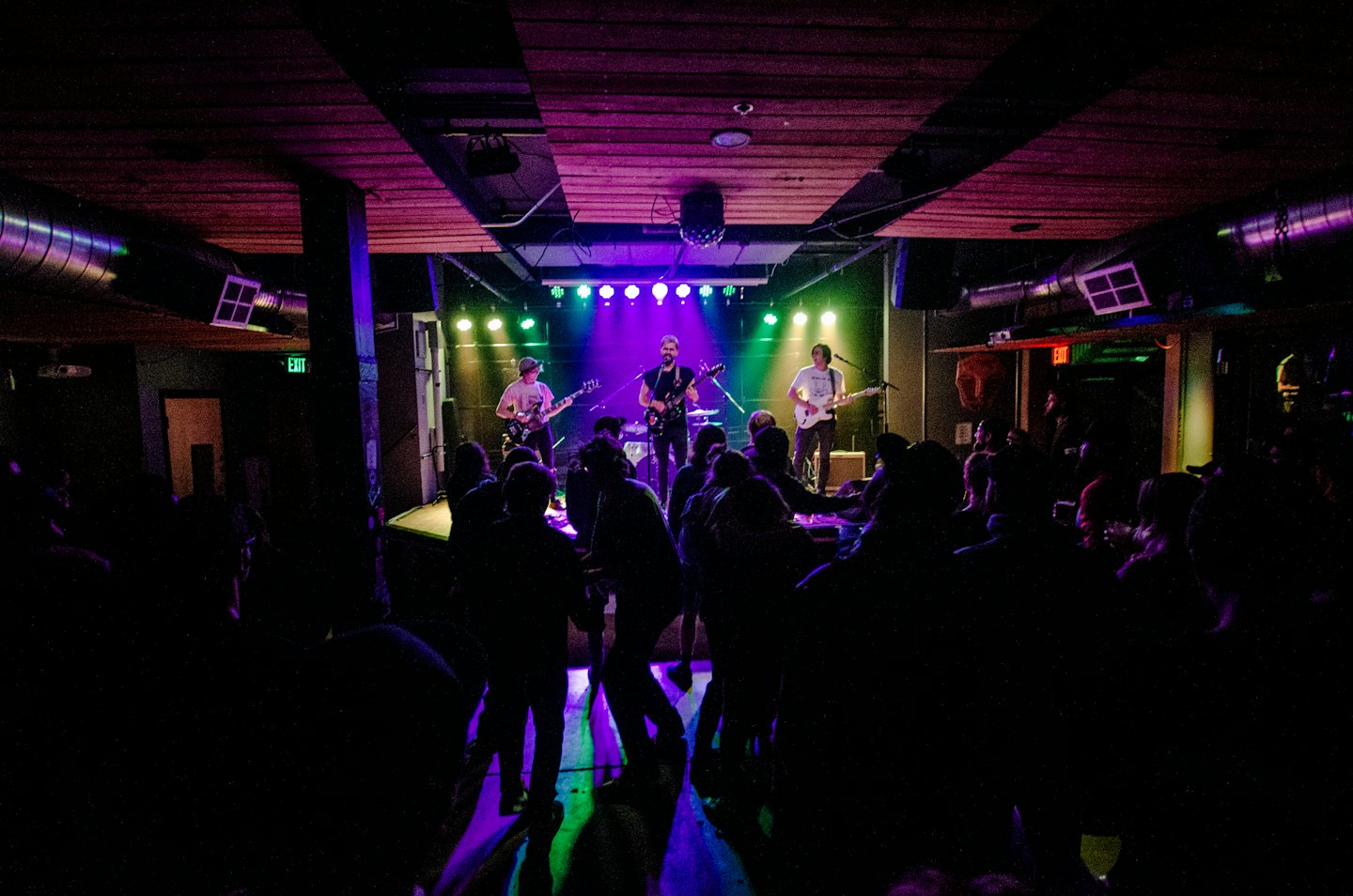 A live band performs for a crowd on stage.
