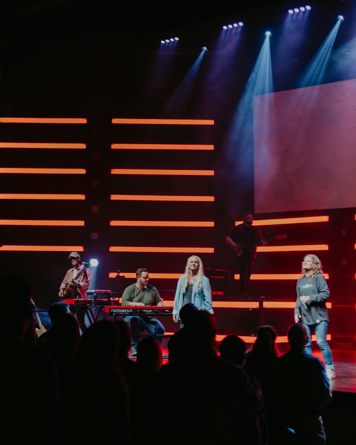 A live band performs on a stage with colorful lights.